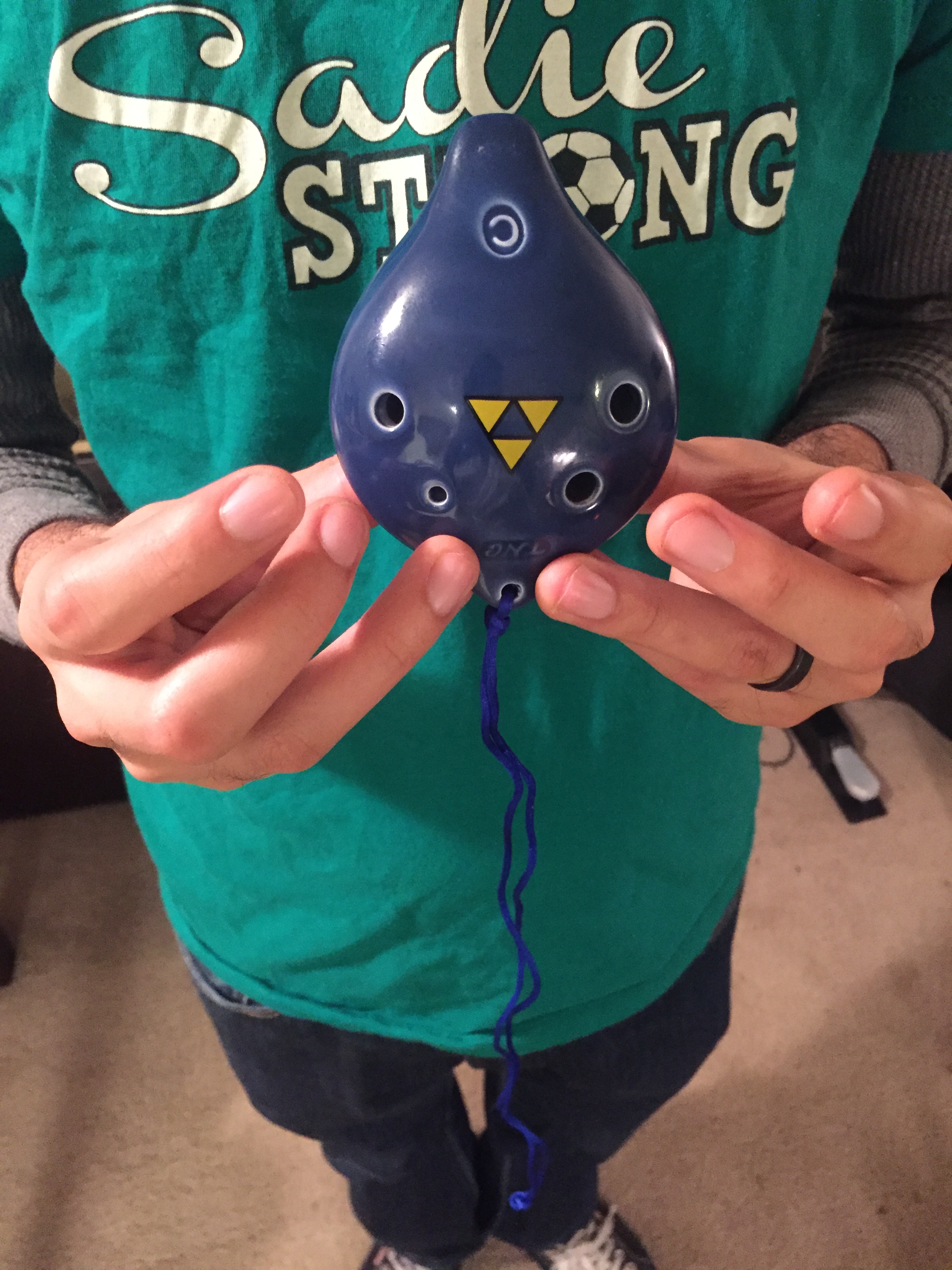 Ocarina Owl holding a 6-hole pendant ocarina